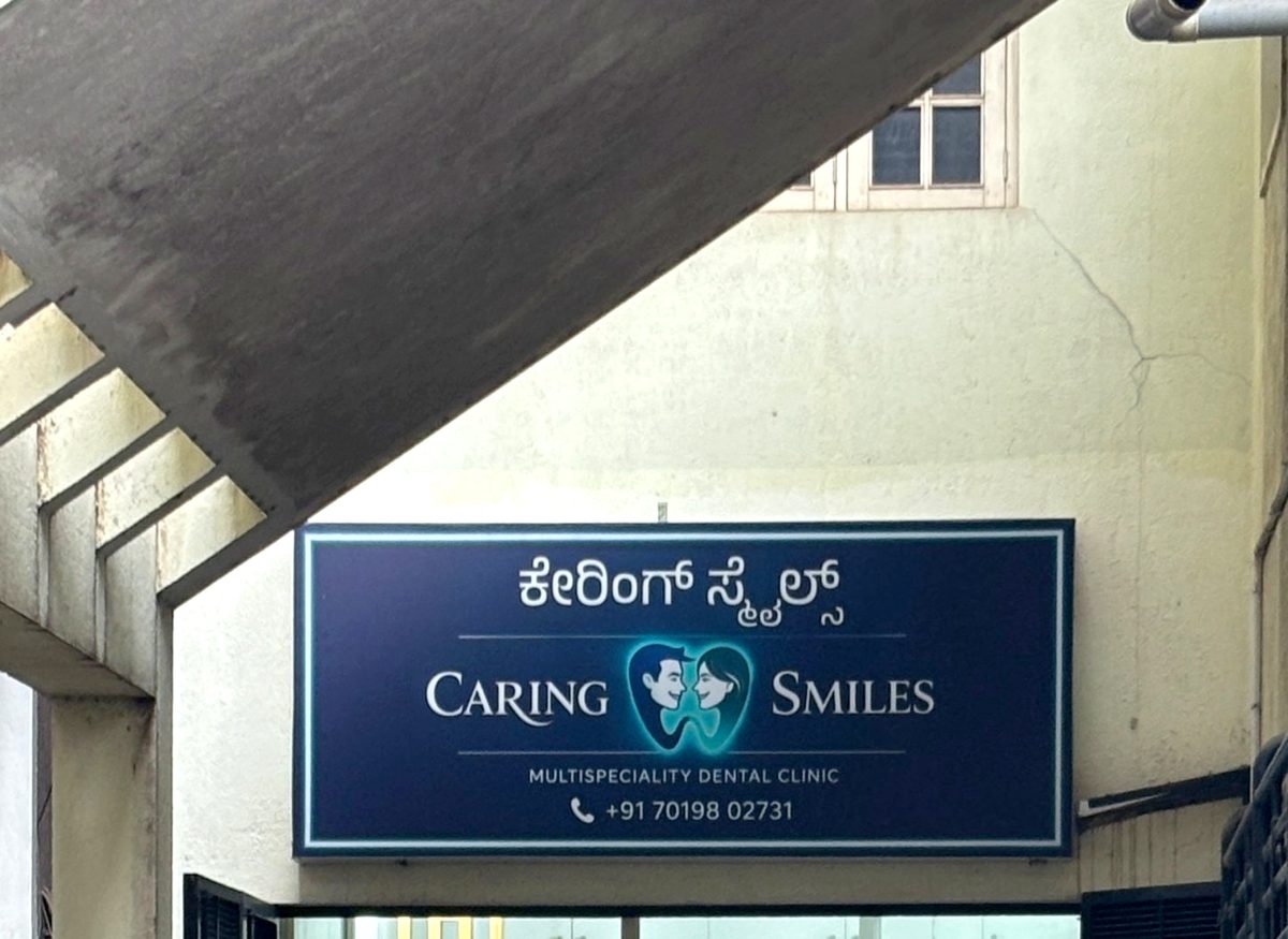 The Caring Smiles sign seen from the lane, under the staircase